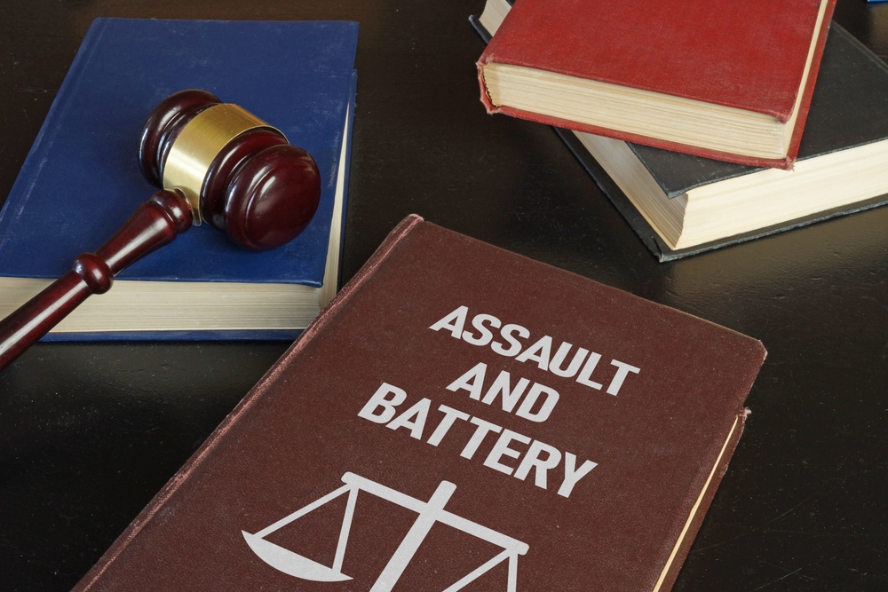 Law books labeled Assault and Battery with a judge’s gavel, symbolizing Texas family assault charges and holiday-related arrests.